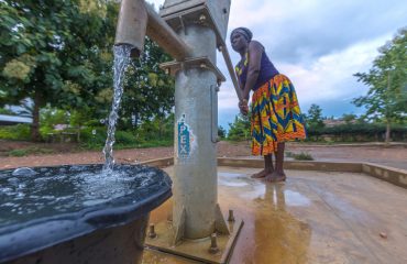 At Bopese, Evelyn Doe fetches water from the hand pump water borehole system donated to the community through the Rotary International-USAID Partnership projects. Bopese, Ghana. 25 June 2019. Rotarians from 35 clubs across the country are partnering with USAID and national and local agencies of the government of Ghana in a large-scale $4 million program in water, sanitation and hygiene serving 75,000 people. By working together, both partners leverage each other strengths for more sustainable impact in improving access to clean water and sanitation services, fostering the adoption of hygiene behavior, strengthen community management systems, and influencing decision makers for prioritized financing of local water and sanitation services.